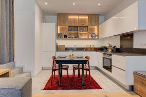 a kitchen with a table and chairs in a kitchen at Apartment Chéserys, Alpes Travel, Les Praz Sleeps 2-4 in Chamonix-Mont-Blanc