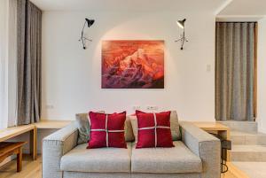 a living room with a couch with red pillows at Apartment Chéserys, Alpes Travel, Les Praz Sleeps 2-4 in Chamonix-Mont-Blanc