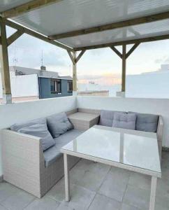 a couch and a table on a balcony at Apartamento AGUA con Jacuzzi y terraza in Las Palmas de Gran Canaria