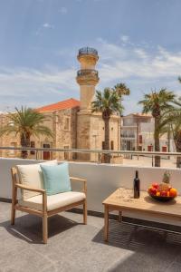 una sedia e un tavolo sul balcone con faro di Ierapetra’s Mosque House a Ierápetra