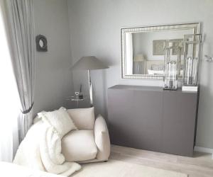 a living room with a white chair and a mirror at VB Domum Hospitum in Krāslava