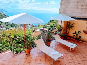 a balcony with two chairs and an umbrella at Castel Tauro Apartment in Taormina
