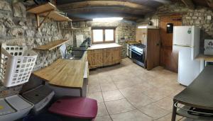 a kitchen with a wooden table and a refrigerator at Albergue Casa Fumenal in Padarniu