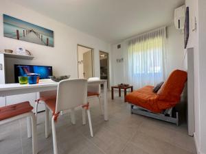 a living room with a table and a desk at Villa Tre Pini in Lignano Sabbiadoro