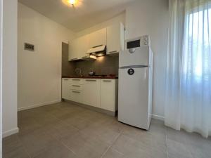 uma cozinha com um frigorífico branco num quarto em Villa Tre Pini em Lignano Sabbiadoro