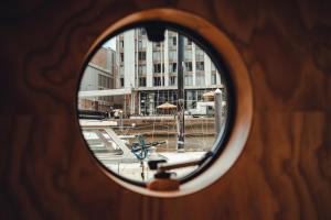 a view of a building through a round window at Wikkelboats at Wijnhaven in Rotterdam