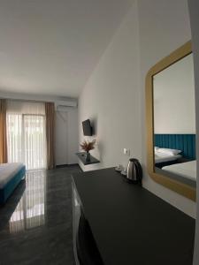 um quarto com um espelho, uma cama e uma secretária em LEODORI 3 suites em Shëngjin
