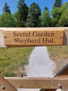 a sign that reads secret garden shepherd hut on a fence at Secret Garden Shepherd Hut in Macclesfield