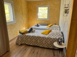 a bedroom with two beds and two windows at Chambres d'hôtes Le Malbouyssou in Lascabanes +26 photos