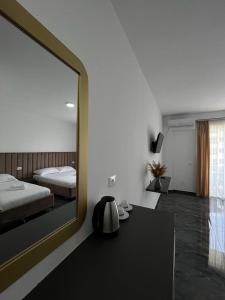 1 dormitorio con espejo grande y cama en LEODORI 3 suites en Shëngjin