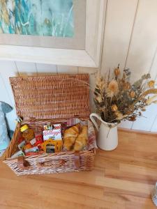 a basket of bread and other snacks on a floor at Secret Garden Shepherd Hut in Macclesfield