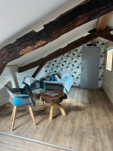 a living room with a blue couch and a table at Chambres d'hôtes Le Malbouyssou in Lascabanes
