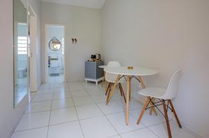 uma sala de jantar branca com uma mesa e cadeiras em Filimahalo Hotel em Serra Negra