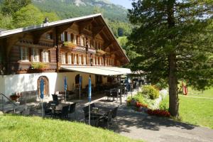 un bâtiment avec des tables et des chaises devant lui dans l'établissement Landgasthof Tännler, à Innertkirchen