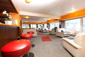 a waiting room with red chairs and couches at Hotel Imperial in Hamburg