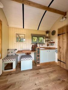 a kitchen with a table and a chair in a room at Secret Garden Shepherd Hut in Macclesfield