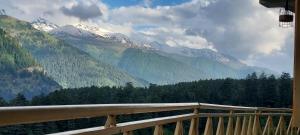 a view of a mountain range from a balcony at UpClimb Longstay for bus or taxi only guests in Manāli