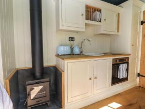 a kitchen with a wood stove in a room at The Hares Rest in Shipston-on-Stour