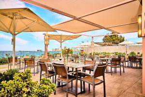 um restaurante com mesas, cadeiras e guarda-sóis em NYX Hotel Ibiza by Leonardo Hotels-Adults Only em Baía de San Antonio