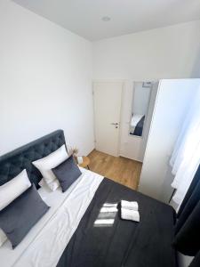 une chambre avec un grand lit avec des oreillers bleus dans l'établissement Apartman Ana, Zadar, à Zadar 9 autres photos
