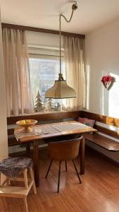 a dining room with a wooden table and a window at Casa Horvais San Candido in San Candido