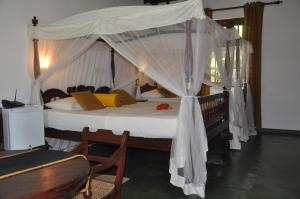 a bedroom with a bed with a canopy at Refresh Cabana Gardens in Kataragama