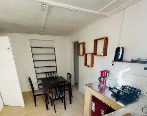 a kitchen with a table and chairs and a dining room at Takasira Appart Hotel centre ville in Fort Dauphin