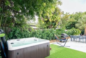 bañera de hidromasaje en un patio con silla en Dog friendly condo with beach access, hot tub, firepit, en West Palm Beach