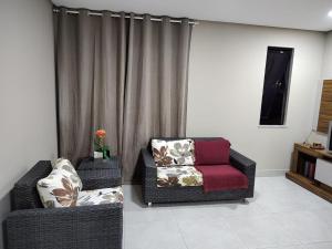 a living room with a couch and a chair at Apartamento 2 Quartos - 5 minutos do São João de Petrolina in Petrolina