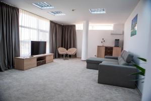 a living room with a couch and a tv at Hotel 2D Resort and Spa in Neptun