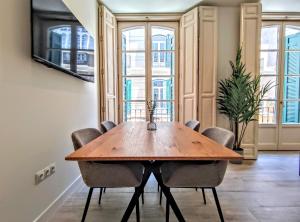 a dining room with a wooden table and chairs at EDIFICIO DUQUE in Málaga