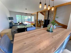 een keuken en een woonkamer met een houten tafel bij Maison familiale vue lac avec jardin - à 10mn du lac et stations de ski in Publier