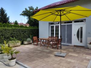 a patio with a table and chairs and a yellow umbrella at Open Space in Varaždin