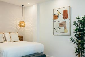 Pietermaai Oasis في فيليمستاد: غرفة نوم مع سرير وزرع الفخار