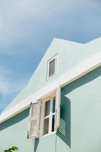 uma casa azul com janelas brancas fechadas em Pietermaai Oasis em Willemstad