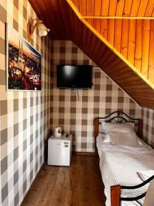 um quarto com uma cama e uma televisão na parede em Zajazd Biały Młyn em Sterławki Wielkie