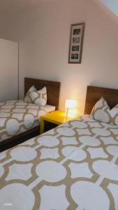 a bedroom with two beds and a table with a lamp at HOKE lakás in Sopron