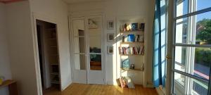 a room with a door and a book shelf with books at La Croisée des Chemins in Arques-la-Bataille