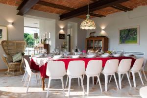 a dining room with a red table and white chairs at Casa San Grato in Monteu Roero