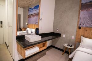 a bathroom with a sink and a bed in a room at CAMPOS DE HOLAMBRA INN in Paranapanema