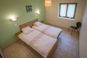 sypialnia z 2 łóżkami i krzesłem w obiekcie Au domaine de chasse w mieście Beauvoir-de-Marc