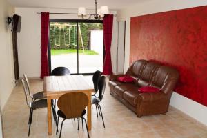 salon ze skórzaną kanapą i stołem w obiekcie Au domaine de chasse w mieście Beauvoir-de-Marc
