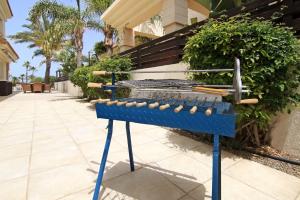 a blue bench with baseball equipment on a sidewalk at Villa Oceania - Beachfront in Paralimni