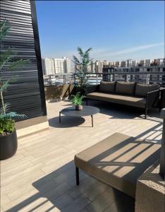 eine Dachterrasse mit einem Sofa und Stadtblick in der Unterkunft Departamento en Santiago centro cerca de movistar arena, Caupolican in Santiago