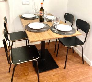 un tavolo in legno con sedie nere e bicchieri da vino di CRUZAMAR Casco Antiguo Centro a Benidorm
