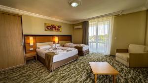 ein Hotelzimmer mit 2 Betten und einem Stuhl in der Unterkunft Prenses Sealine Beach Hotel in Serik