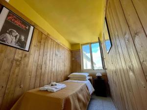1 Schlafzimmer mit 2 Betten an einer Holzwand in der Unterkunft Spaccanapoli Top, your house in the old town in Neapel