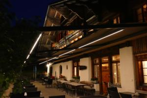 an outdoor patio with tables and chairs at night at Landgasthof Tännler in Innertkirchen