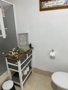 a bathroom with a toilet and a table with a sink at Cozy Inn in Perth