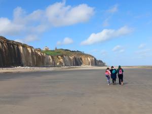 3 personnes marchant sur la plage avec des falaises en arrière-plan dans l'établissement La Croisée des Chemins, à Arques-la-Bataille